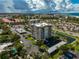 Stunning aerial view of condo building with a pond and lush landscaping at 1001 Beach Rd # A203, Sarasota, FL 34242
