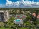 Scenic aerial view of the community featuring lush green landscaping, pool, and tennis courts at 1001 Beach Rd # A203, Sarasota, FL 34242