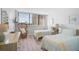 Cozy bedroom with twin beds, wicker chair, light wood floors, and a large window for natural light at 1001 Beach Rd # A203, Sarasota, FL 34242