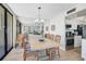 Open dining area featuring a table, chairs, and views of the kitchen and balcony at 1001 Beach Rd # A203, Sarasota, FL 34242
