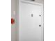 Image of the front door featuring a white door, silver hardware, and an emergency alarm box at 1001 Beach Rd # A203, Sarasota, FL 34242