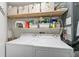 Convenient laundry room with washer, dryer, and storage shelves at 1001 Beach Rd # A203, Sarasota, FL 34242