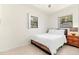 A simple bedroom with a wooden bed frame, natural light, and terrazzo floors at 1011 68Th W Ave, Bradenton, FL 34207
