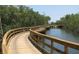 Scenic wooden boardwalk winding through lush greenery and over calm water at 1011 68Th W Ave, Bradenton, FL 34207