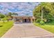 Single story home with a covered parking, landscaped lawn, and a concrete driveway at 1011 68Th W Ave, Bradenton, FL 34207
