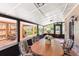 Bright sunroom with a dining table, offering a relaxing space with views of the beautiful backyard and pool at 1011 68Th W Ave, Bradenton, FL 34207