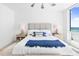 Bright bedroom with a large luxurious bed, side tables, and an ocean view at 1035 Seaside Dr # 603, Sarasota, FL 34242