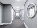Well-lit hallway with gray wallpaper, white trim, patterned carpet, and a decorative mirror at 1035 Seaside Dr # 603, Sarasota, FL 34242
