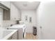 Bright laundry room with modern washer and dryer, storage cabinets, and tiled flooring at 1035 Seaside Dr # 603, Sarasota, FL 34242