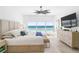 Bright main bedroom with a luxurious bed, ceiling fan, and stunning ocean views from the large window at 1035 Seaside Dr # 603, Sarasota, FL 34242