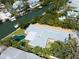 Aerial view of a home on a canal with a backyard pool surrounded by lush greenery at 110 Faubel St, Sarasota, FL 34242