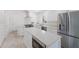 A modern, all-white kitchen featuring stainless steel appliances and a large island with seating at 110 Faubel St, Sarasota, FL 34242