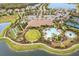 Aerial view of clubhouse with pool, spa, tennis courts, lawn bowling, and surrounding homes at 11127 Devonbridge Dr, Palmetto, FL 34221