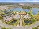 Aerial view showcases community clubhouse, tennis courts, and lake, with nearby residential area at 11127 Devonbridge Dr, Palmetto, FL 34221