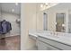 Bathroom featuring white vanity with gold fixtures, access to the walk-in closet, and a large mirror at 11127 Devonbridge Dr, Palmetto, FL 34221