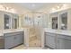 Bathroom with double sink, gray vanity, and seamless glass door shower with built-in shelf at 11127 Devonbridge Dr, Palmetto, FL 34221
