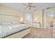 Bedroom featuring a coastal-themed bed, ceiling fan, and doorways to the bathroom and hallway at 11127 Devonbridge Dr, Palmetto, FL 34221