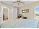 Bedroom featuring a ceiling fan, a window with shutters, a computer desk, and a bed with a patterned comforter at 11127 Devonbridge Dr, Palmetto, FL 34221