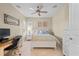 Comfortable bedroom with ceiling fan, a shuttered window, desk area, and five-drawer chest at 11127 Devonbridge Dr, Palmetto, FL 34221