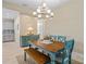 Bright dining area featuring a stylish chandelier, farmhouse table, and bench seating at 11127 Devonbridge Dr, Palmetto, FL 34221