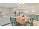 Open-concept dining area with a chandelier, wood table, and access to the kitchen and living room at 11127 Devonbridge Dr, Palmetto, FL 34221