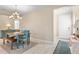 Open-concept dining area with a chandelier, farmhouse table, bench seating, and access to the front door at 11127 Devonbridge Dr, Palmetto, FL 34221