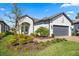 Charming single-story home with gray tile roof, lush landscaping, and a well-manicured front yard at 11127 Devonbridge Dr, Palmetto, FL 34221
