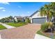 Well-maintained home with gray roof, paver driveway and lush tropical landscaping at 11127 Devonbridge Dr, Palmetto, FL 34221