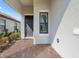 Close-up of the front door with a brick walkway, landscaping, and covered entryway at 11127 Devonbridge Dr, Palmetto, FL 34221