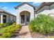 Inviting front entrance with a brick walkway, manicured landscaping, and covered entryway at 11127 Devonbridge Dr, Palmetto, FL 34221
