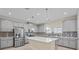 Modern kitchen with gray cabinets, stainless steel appliances, a large center island, and decorative tile backsplash at 11127 Devonbridge Dr, Palmetto, FL 34221