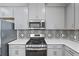 Modern kitchen boasts stainless steel appliances, gray cabinetry, and designer backsplash at 11127 Devonbridge Dr, Palmetto, FL 34221