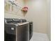 Modern laundry room with a gray washing machine, a gray dryer, and a wire rack at 11127 Devonbridge Dr, Palmetto, FL 34221