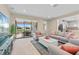 Bright and airy living room featuring neutral tones, modern furniture, and a sliding glass door leading to the outdoor patio at 11127 Devonbridge Dr, Palmetto, FL 34221