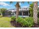 Spacious backyard featuring a screened-in pool area, lush greenery, and a well-maintained lawn, ideal for outdoor enjoyment at 12370 Marsh Pointe Rd, Sarasota, FL 34238
