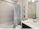 Cozy bathroom with a tub/shower combo, vanity and nautical-themed artwork at 12370 Marsh Pointe Rd, Sarasota, FL 34238