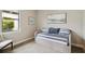 Serene bedroom featuring a daybed, soft hues, and a view to a lush exterior landscape at 12370 Marsh Pointe Rd, Sarasota, FL 34238