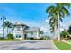 Gated entrance to a community, featuring palm trees, lush landscaping, and elegant architecture at 12370 Marsh Pointe Rd, Sarasota, FL 34238