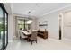 Well-lit dining room featuring a wooden table, modern chandelier, and an open view of outdoor greenery at 12370 Marsh Pointe Rd, Sarasota, FL 34238