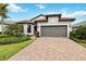 Charming single-story home with a paver driveway and a well-manicured lawn at 12370 Marsh Pointe Rd, Sarasota, FL 34238