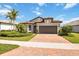Beautiful single-story home with lush landscaping, brick driveway, and a tile roof at 12370 Marsh Pointe Rd, Sarasota, FL 34238