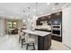 Open kitchen with island seating, dark cabinets, stainless appliances, and view to the dining area at 12370 Marsh Pointe Rd, Sarasota, FL 34238