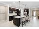 Spacious kitchen showcasing dark wood cabinets, granite countertops, a large island with barstool seating and modern appliances at 12370 Marsh Pointe Rd, Sarasota, FL 34238