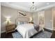 Bedroom showcasing a stylish chandelier, neutral tones, and a doorway leading to a spa-like bathroom at 12370 Marsh Pointe Rd, Sarasota, FL 34238