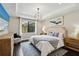 Comfortable main bedroom offers tray ceilings, a large window, neutral tones and stylish decor at 12370 Marsh Pointe Rd, Sarasota, FL 34238