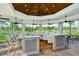Screened outdoor kitchen with a large bar, ceiling fans, and views of the surrounding greenery at 12370 Marsh Pointe Rd, Sarasota, FL 34238