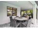 Covered outdoor dining area with a round table and stylish seating, perfect for gatherings and enjoying outdoor meals at 12370 Marsh Pointe Rd, Sarasota, FL 34238