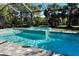 Screened-in pool and spa boasts cool blue water, lush landscaping, and a paved deck for relaxation and enjoyment at 12370 Marsh Pointe Rd, Sarasota, FL 34238