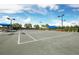 Outdoor tennis court with blue canopies, surrounded by greenery, offering a great recreational space at 12370 Marsh Pointe Rd, Sarasota, FL 34238
