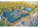 Aerial view of community tennis and pickleball courts, surrounded by lush landscaping and parking at 12370 Marsh Pointe Rd, Sarasota, FL 34238